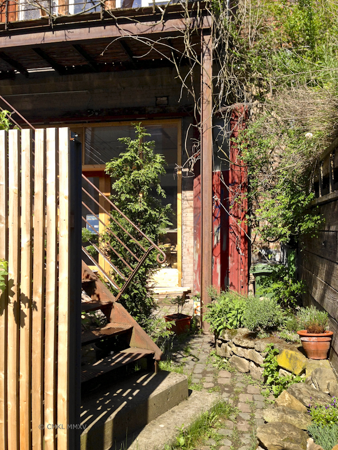This romantic garden includs a set of red former mashine shop doors